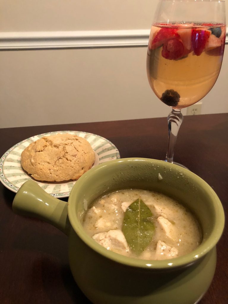 A bowl of chicken & barely stew, an almond biscuit, and a glass of beltane berry sangria