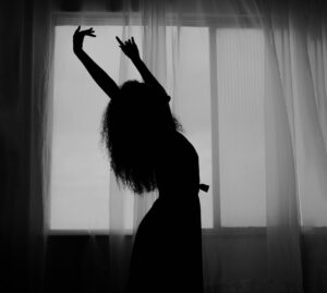 silhouette of a woman with long curly hair dancing